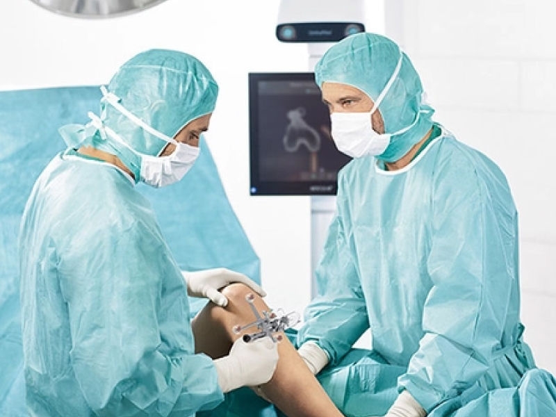 手術室に OrthoPilot® Elite ナビゲーションシステムを搭載した外科医 2 名